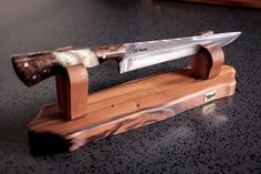 a knife that is on top of a wooden stand