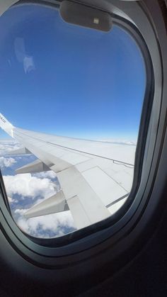 an airplane window looking out at the clouds