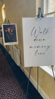 a white sign with writing on it in front of a window next to a carpeted floor