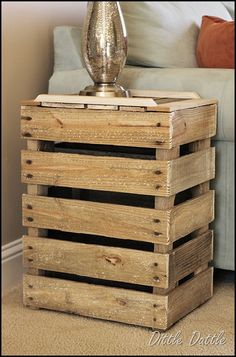 a wooden crate sitting on top of a floor next to a white couch and lamp