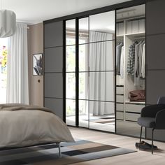 a bedroom with a bed, chair and mirrored closet doors