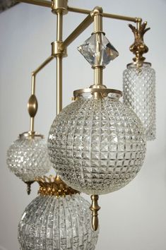 three clear glass balls hanging from a brass chandelier