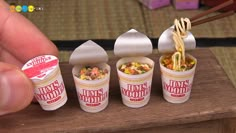 the miniature food is being held up to show it's different flavors and ingredients