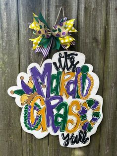 the mardi gras door hanger is hanging on a fence