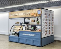 a food stand with many items on display in the middle of an empty floored room