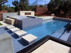 an outdoor swimming pool with steps leading up to it and landscaping in the back ground