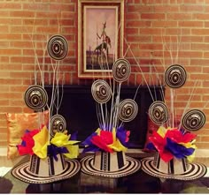 three vases with colorful flowers are sitting in front of a brick wall and fireplace