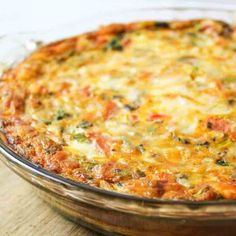 a casserole with cheese and vegetables in a glass dish on a wooden table