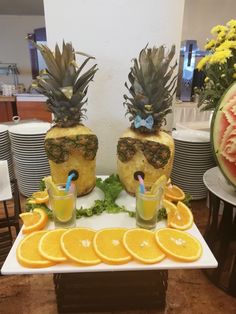 there are pineapples and orange slices on the table with juice in glasses next to them