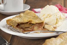 a piece of pie sitting on top of a white plate next to a fork and knife