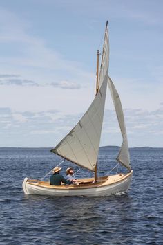 two people in a small sailboat on the water