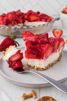 a piece of cheesecake with strawberries on top and a fork next to it