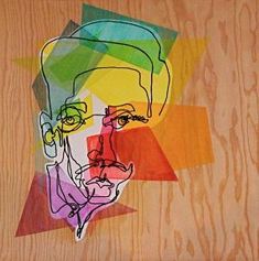 a drawing of a man's face is shown in multicolored paper on wood