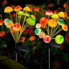 three solar powered garden lights in the shape of flowers and butterflies on top of each other