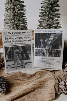 two christmas tree cards sitting on top of a table next to pine cones and other decorations