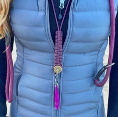 a woman wearing a blue vest with purple and pink beads on it's neck