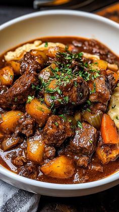 a white bowl filled with stew and potatoes