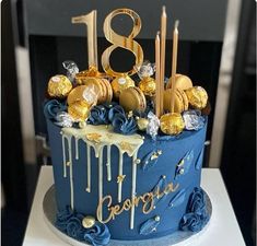 a blue birthday cake with gold decorations and the number eight on it's side