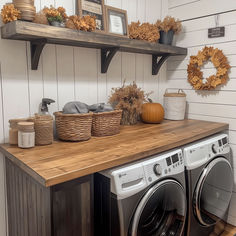 a washer and dryer sitting on top of a wooden counter in a laundry room