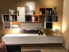 a living room filled with furniture and bookshelves next to a wall mounted book shelf