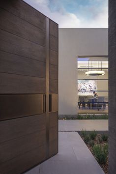 the entrance to a modern home with wood doors