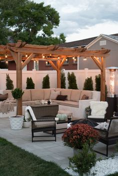 an outdoor living area with couches, chairs and fire pit in the back yard