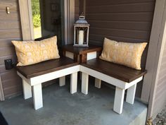 two wooden benches sitting next to each other on a cement floor near a house door