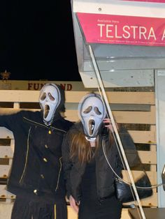 two people wearing masks standing next to each other