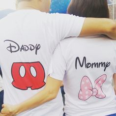 two people wearing matching shirts that say daddy, mommy and mickey mouse on their back