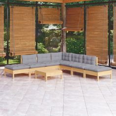 a large sectional couch sitting on top of a white tile floor next to a green plant