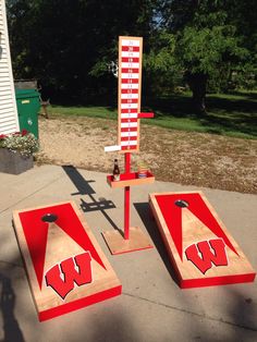 two cornhole game boards with the university of wisconsin logo painted on them sitting in front of a house