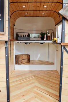 the inside of a small kitchen with wood floors and white walls, along with wooden flooring