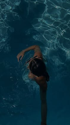 a woman swimming in the water with her arms outstretched