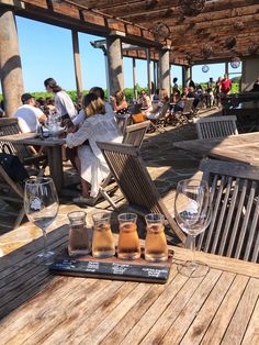 people sitting at wooden tables with wine glasses on them