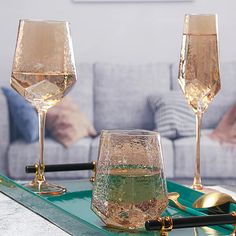 two champagne glasses sitting on top of a green tray