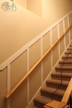 an empty staircase leading up to the second floor with carpeted stairs and handrails