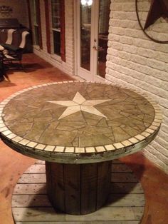 a round table with a star on it in front of a brick wall and door