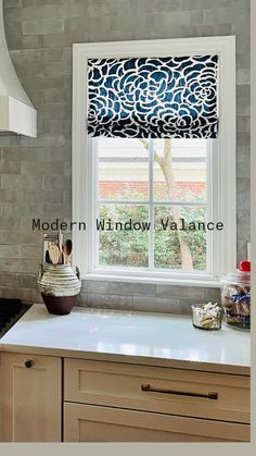 a kitchen window with an intricate design on the blind in it's valance