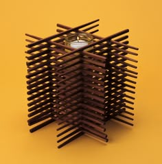 a candle holder made out of wooden slats on an orange background with a yellow backdrop