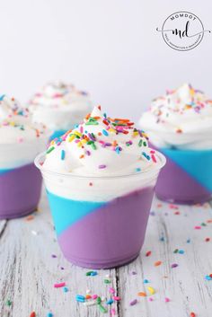 cupcakes with white frosting and sprinkles are on a table