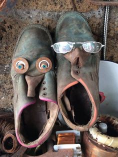 two shoes with googly eyes and eye glasses on top of each one, surrounded by other objects