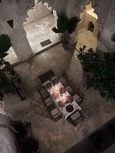 an overhead view of a table and chairs in a room with potted plants on the floor