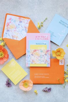 an orange envelope with flowers and cards on it, surrounded by other items from the book