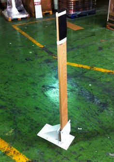 a tall wooden pole sitting on top of a green floor