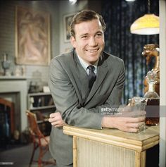 a man in a suit and tie leaning on a table