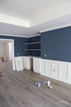 an empty room with blue walls and white trim on the wall is being painted in progress