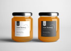 two jars of raw honey sitting side by side