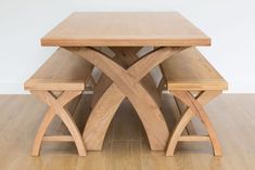 a wooden table and bench sitting on top of a hard wood floor