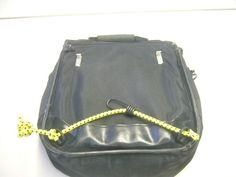 a black bag with a yellow rope attached to the front and side of it, sitting on a white surface