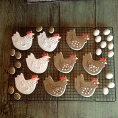 several decorated cookies on a cooling rack with eggs and chocolates in the shape of chickens